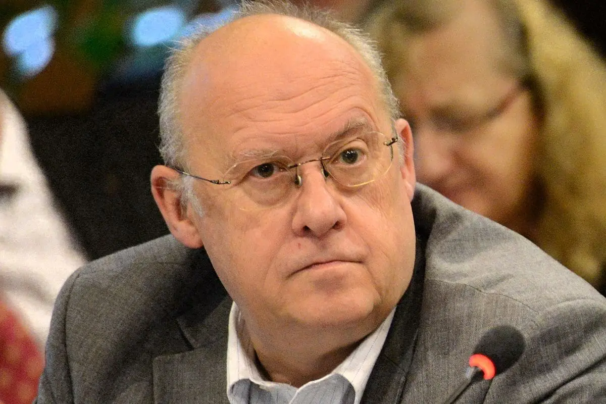 Serious man with glasses at a meeting.